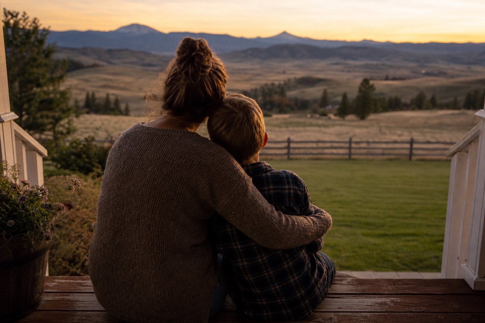 Parent and child seen from behind looking over Montana fields