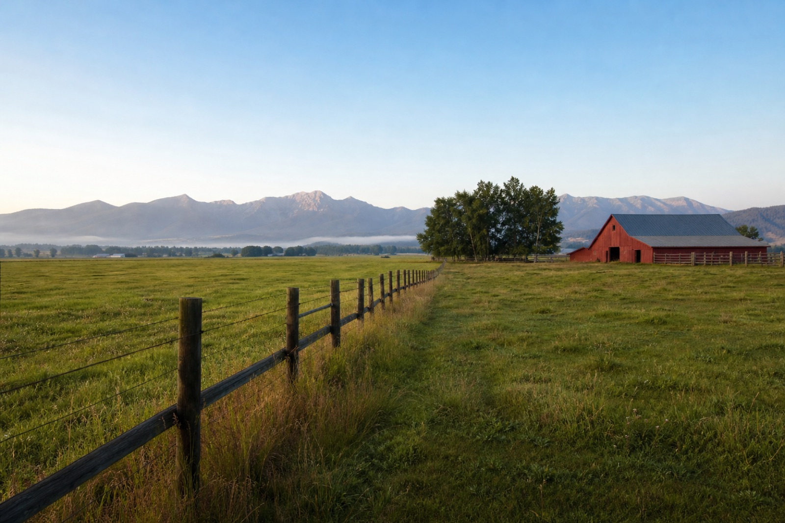 Fenced pasture and red barn near Churchill with mountains in the distance
