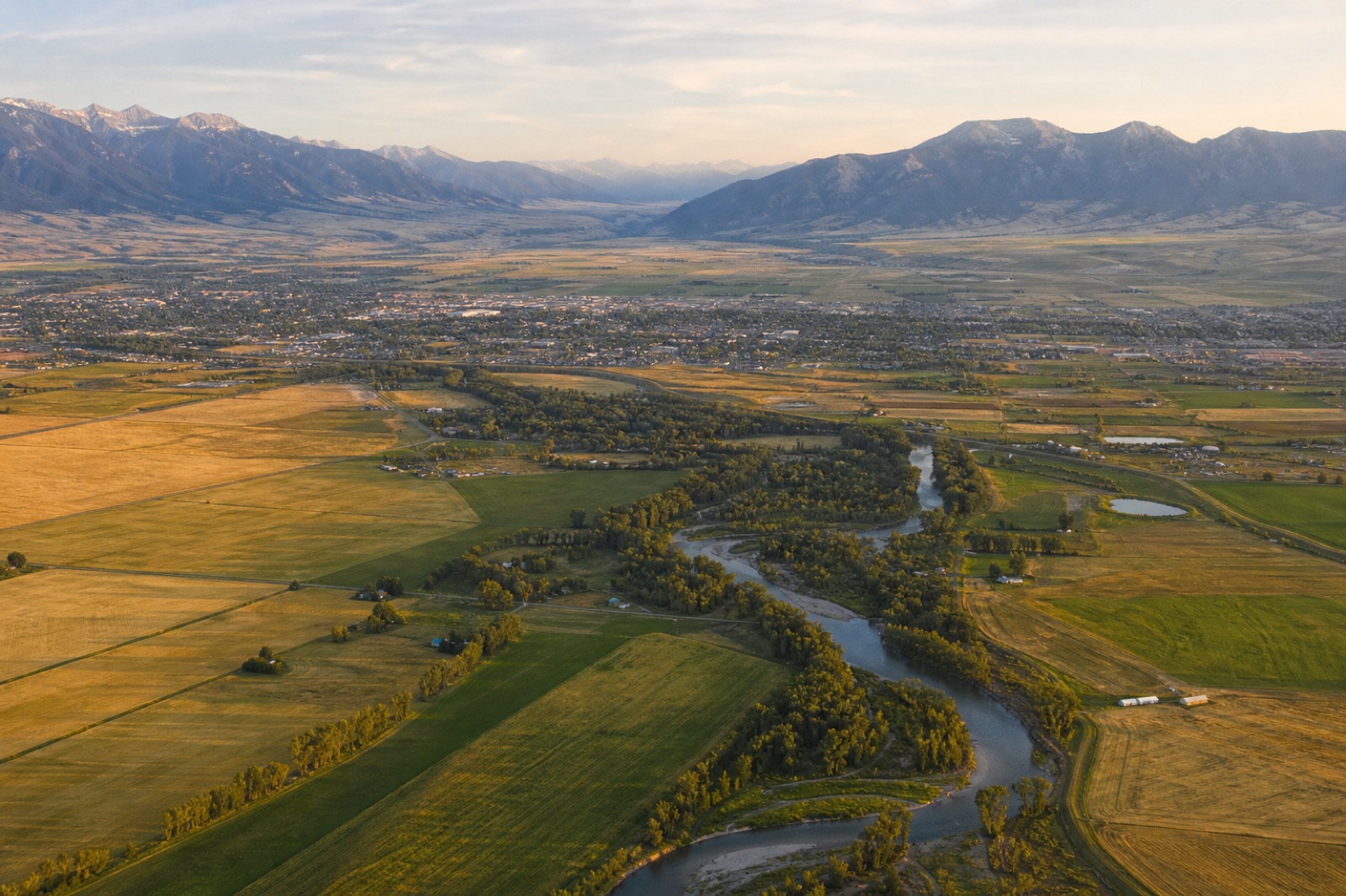 Gallatin Valley fields and a winding river beneath Montana mountains